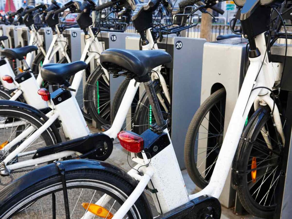 Outdoor bike-sharing station with rows of parked bicycles in an urban mobility setting
